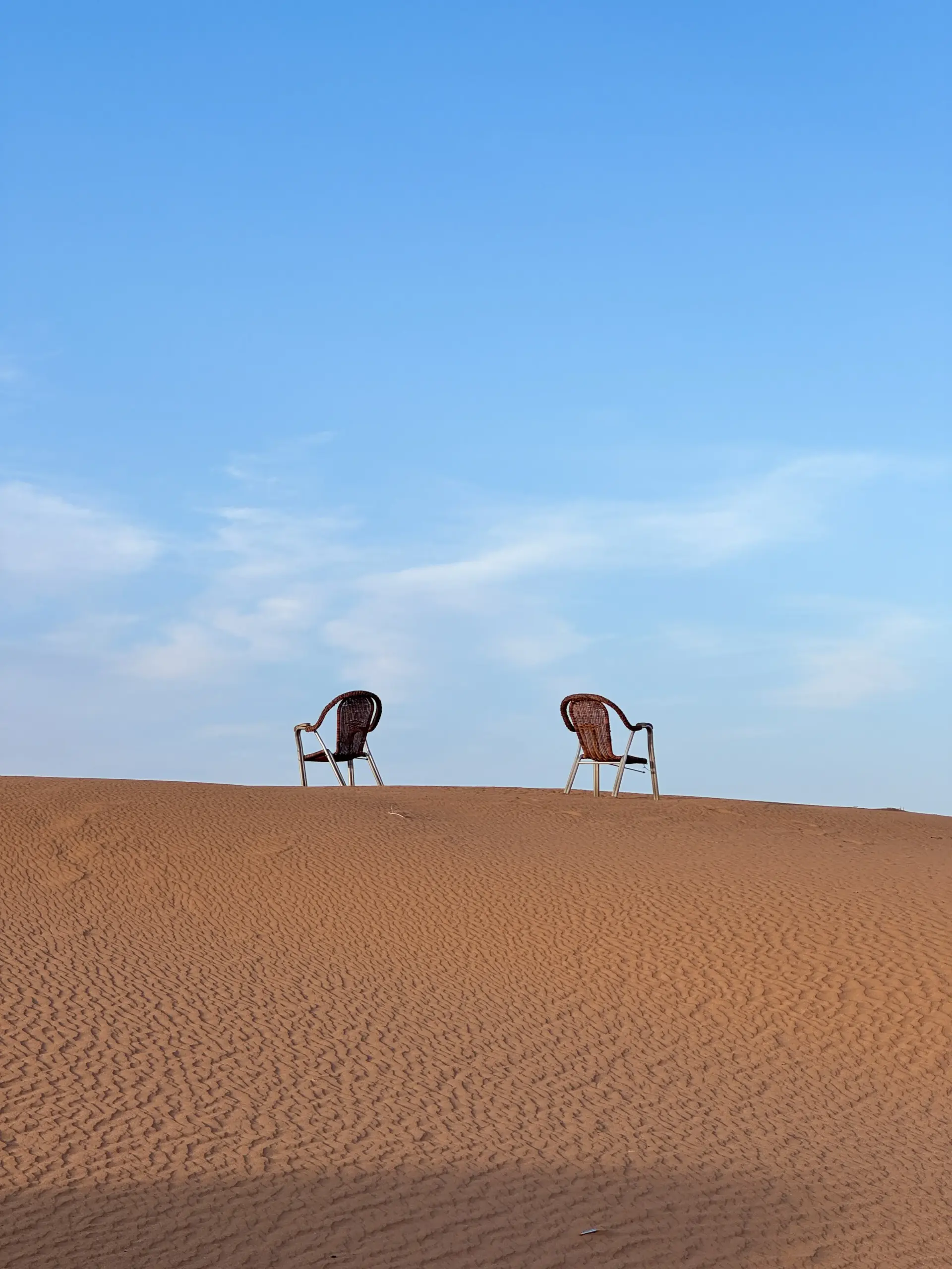 Two chairs on a sand dune