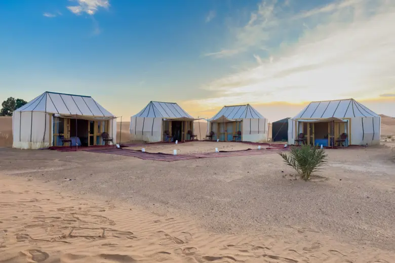 Row of white guest tents at Ame Camp