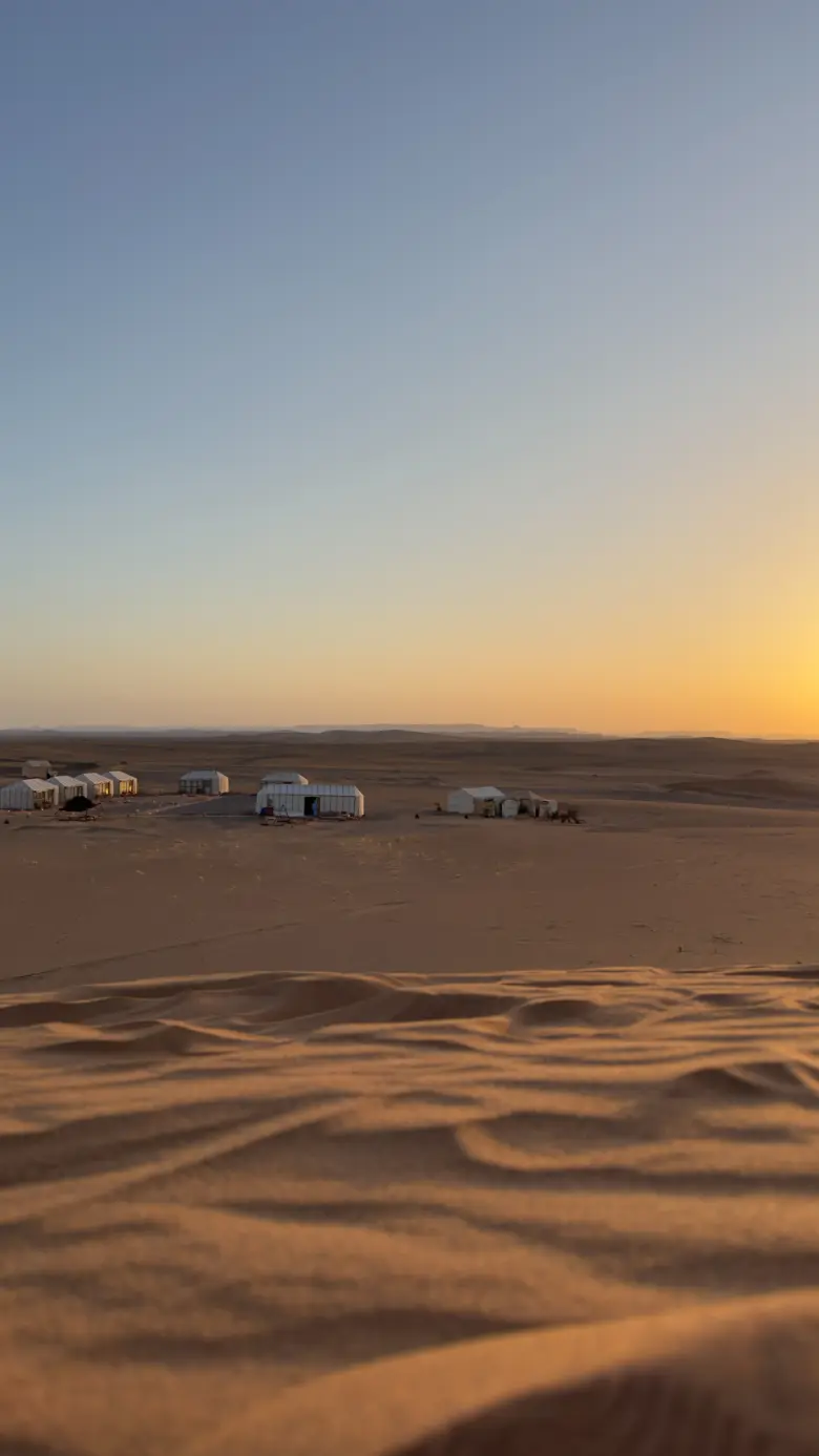 Ame Camp tents among the dunes at sunset
